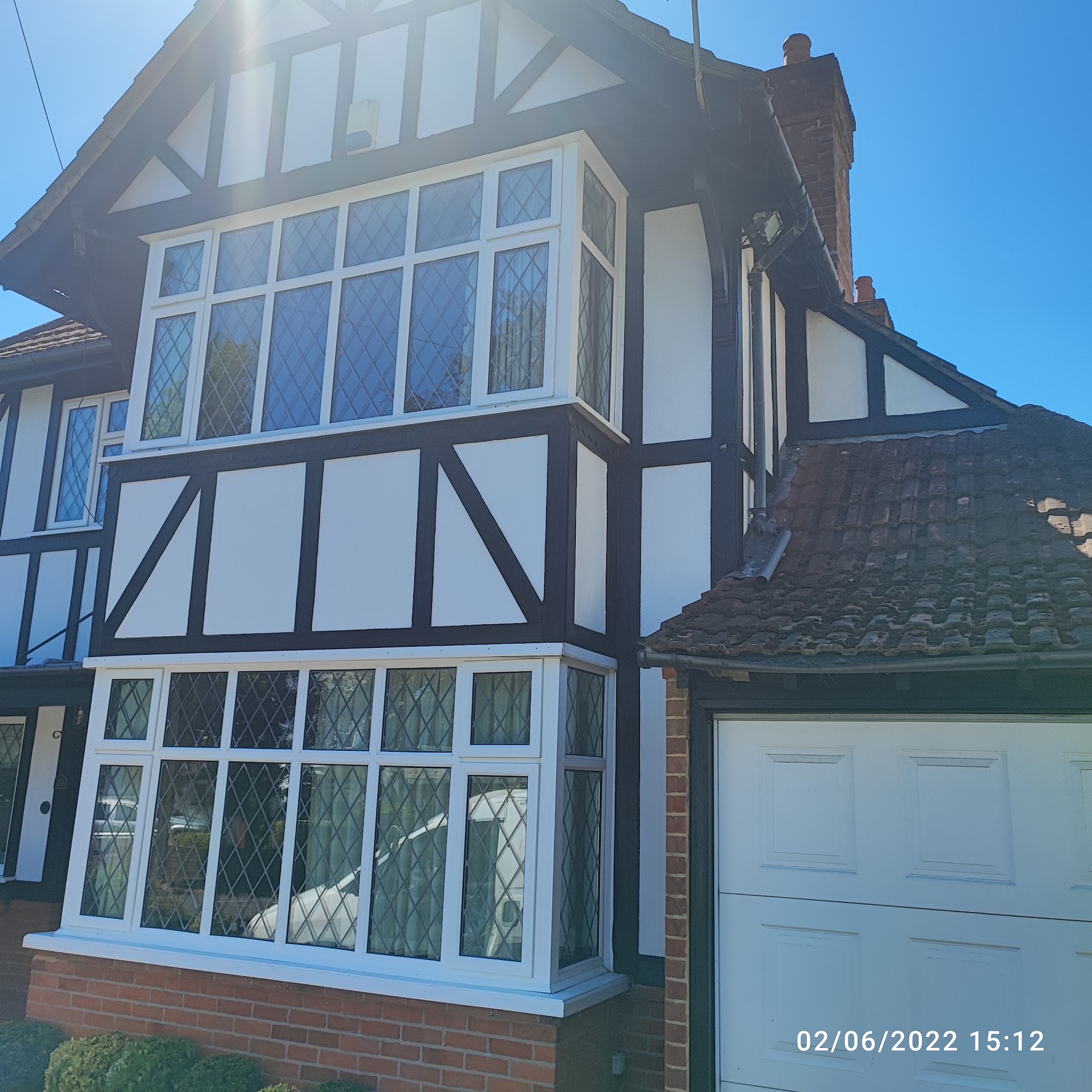 Mock Tudor house with black and white gable and freshly painted leaded bay windows